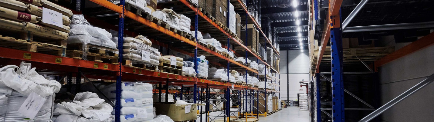 Eine Lagerhalle mit Hochregalen und LED tubes an der Decke