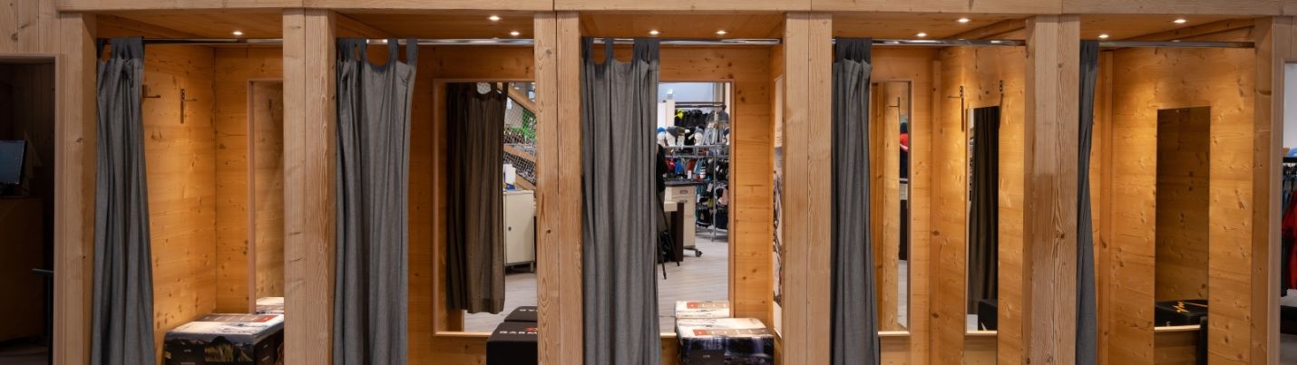 Umkleidekabinen in einem Modegeschäft mit Downlights an der Decke