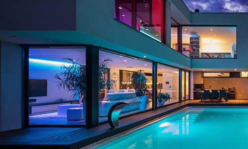 Beleuchteter Pool vor modernem Haus