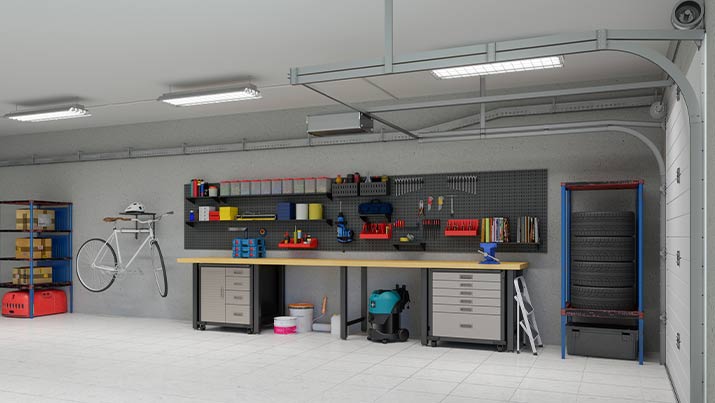 Eine Werkbank mit Werkeugen an einer Wand und Feuchtraumbeleuchtung an der Decke.