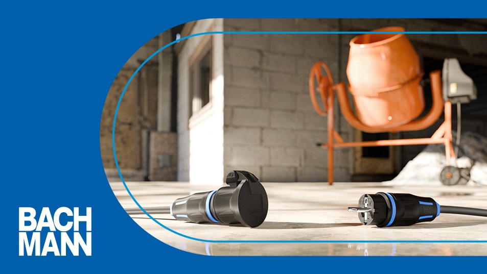 Zwei Kupplungen und Stecker liegen auf dem Boden vor einem Betonmischer