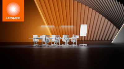 Eine weiße Sitzgruppe mit Tisch vor einem orangefarbenen fächerartigen Hintergrund
