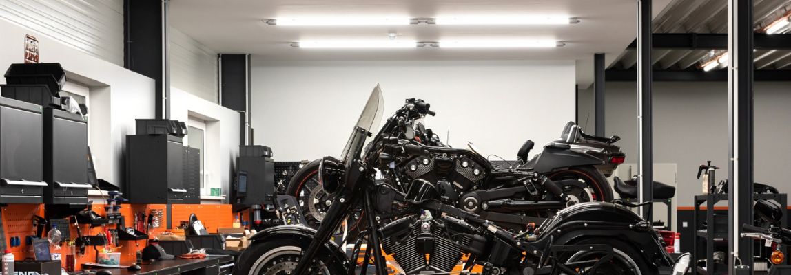 Ein Werkstattraum mit Motorrädern und Herstellerleuchten an der Decke