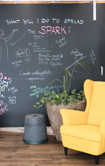 Beschriftete Tafel mit gelben Sessel