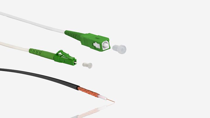 Grüne Glasfaser‑APC‑Steckverbinder und aufgeschnittenes Koaxialkabel für moderne Datenübertragung